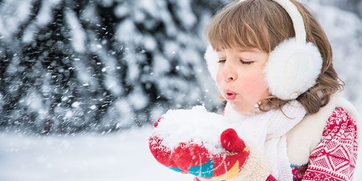 little girl blowing snow